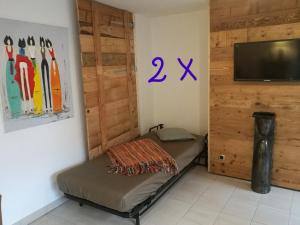 een kamer met een bed en een televisie en een muur bij L'Appart du Vigneron in Turckheim