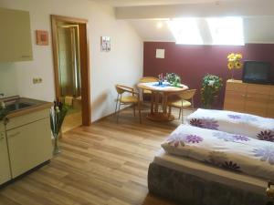 a room with two beds and a table and a kitchen at Ferienwohnung Berger in Bad Birnbach