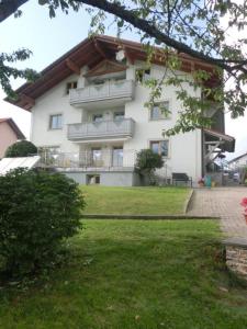 a large white building with balconies and a yard at Ferienhaus Gustl in Bischofsreut