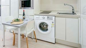 a kitchen with a washing machine and a table with a sink at Sokcho Sono Residence in Sokcho