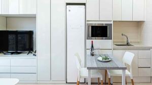 a kitchen with a table with white chairs and a television at Sokcho Sono Residence in Sokcho