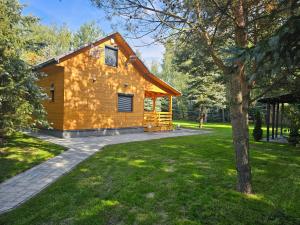 a log cabin in a park with a tree at Odpoczynkowo in Orle