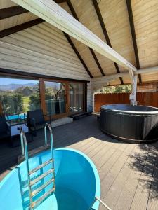 an outdoor deck with a hot tub and a wooden ceiling at Verdant House in Mykulychyn