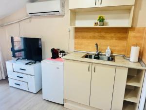 a small kitchen with a sink and a microwave at Room Nencheva in Sandanski +1 photo