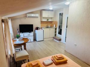 a room with a kitchen and a living room with a table at Room Nencheva in Sandanski