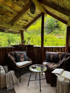 a screened in porch with two chairs and a table at A-Wine Villas in Novaci-Străini