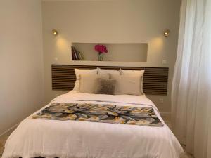 a bedroom with a large bed with a flower vase at La CléryNette in Les Andelys