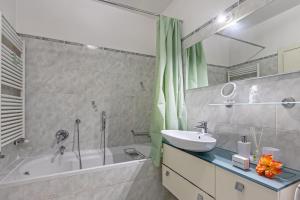 a bathroom with a tub and a sink and a bath tubermottermott at Suite 22 - Happy Rentals in Riva del Garda