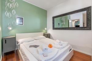 a bedroom with a bed with a mirror on the wall at Suite 22 - Happy Rentals in Riva del Garda