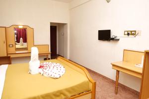 a hospital room with a bed and a mirror at Sakthi Hotel in Pollāchi
