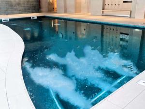 a swimming pool with a cloud in the water at Novotel York Centre in York