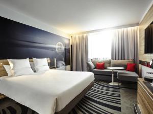 a hotel room with a large bed and a couch at Novotel York Centre in York