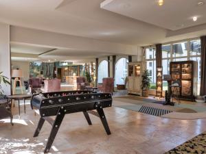 a living room with a pool table in the middle at Hotel Mercure Parc du Coudray - Barbizon in Le Coudray-Montceaux