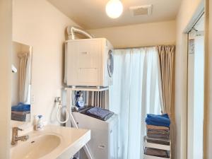 a small bathroom with a refrigerator and a sink at seragaki blue twins 201 in Onna +23 photos
