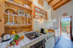 a kitchen with wooden cabinets and a stove top oven at Casa Tra Borgo e Lago in Lake Tenno - Happy Rentals in Tenno