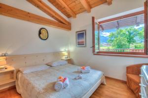 a bedroom with a bed and a window at Casa Tra Borgo e Lago in Lake Tenno - Happy Rentals in Tenno