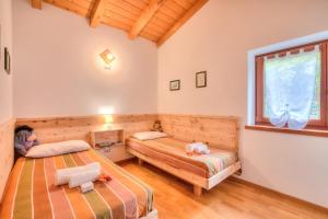 a bedroom with two beds and a window at Casa Tra Borgo e Lago in Lake Tenno - Happy Rentals in Tenno