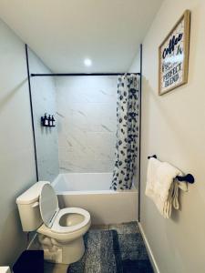 a bathroom with a toilet and a bath tub at Chic City Escape- come experience tranquility! in Calgary +12 photos