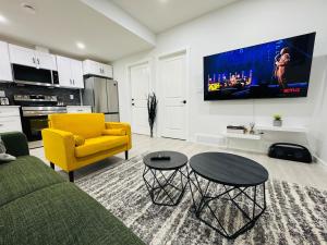 a living room with a couch and a yellow chair at Chic City Escape- come experience tranquility! in Calgary