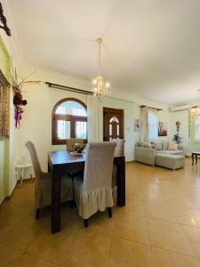 a dining room and living room with a table and chairs at The Greek Mama's Cottage in Epanomi