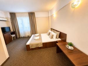 a hotel room with a bed and a table at Casa Mario in Eforie Nord