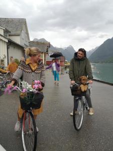 a man and woman riding bikes with a teddy bear in a basket at Meiriet1936 in Fjarland
