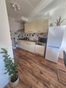 a kitchen with white cabinets and a wooden floor at O21 Apartment in Amersfoort