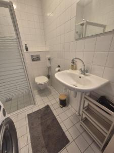 a white bathroom with a sink and a toilet at O21 Apartment in Amersfoort +12 photos