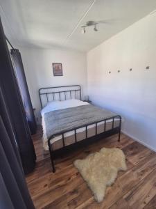 a bedroom with a bed and a rug on a wooden floor at O21 Apartment in Amersfoort