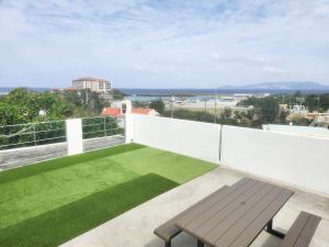 a balcony with a bench and green grass at seragaki blue twins 201 in Onna