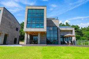 a large stone building with a lawn in front of it at Goseung Poolhouse Poolvilla 151 in Goseong