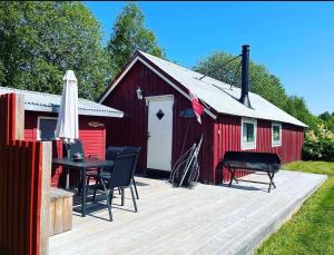 a red barn with a table and a grill and a piano at Bakerstu in Skage i Namdalen