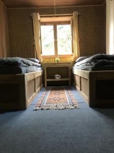 a bedroom with two beds and a window at Hotel Waterfall Benkar in Phakding