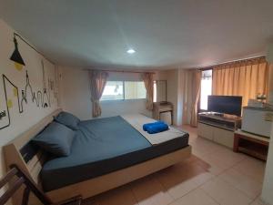 a bedroom with a large bed and a television at TaKaYai GuestHouse in Cha Am