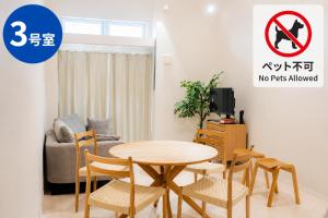 Ein Wohnzimmer mit Tisch und Stühlen, an dem ein Schild mit der Aufschrift „Haustiere nicht erlaubt“ hängt. in der Unterkunft Green Field in Sasebo