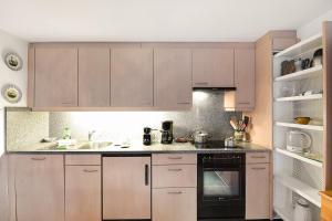 a kitchen with wooden cabinets and a sink at Rustico Alla Bolla - Val Verzasca - Happy Rentals in Frasco