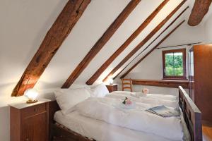 a bedroom with a bed with white sheets and a window at Rustico Alla Bolla - Val Verzasca - Happy Rentals in Frasco