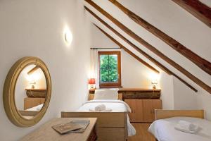 a bedroom with two beds and a mirror at Rustico Alla Bolla - Val Verzasca - Happy Rentals in Frasco