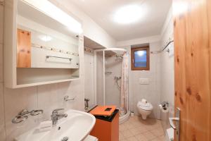 a white bathroom with a sink and a toilet at Rustico Alla Bolla - Val Verzasca - Happy Rentals in Frasco +15 photos