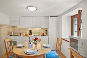 a kitchen with a wooden table with chairs and a dining room at Rustico Esterina in Val Verzasca for 4 - Happy Rentals in Lavertezzo