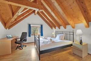 a bedroom with a bed and a desk and a chair at Rustico Esterina in Val Verzasca for 4 - Happy Rentals in Lavertezzo