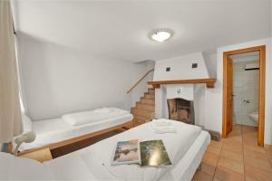 a room with two beds and a fireplace at Rustico Esterina in Val Verzasca for 4 - Happy Rentals in Lavertezzo +19 photos