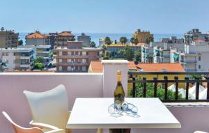 a bottle of wine and glasses on a table on a balcony at Riviera Apartments in Pietra Ligure