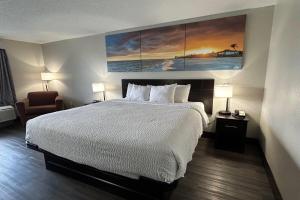 a hotel room with a bed and a chair at Days Inn by Wyndham Savannah Airport in Savannah