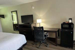 a hotel room with a bed and a desk with a computer at Days Inn by Wyndham Savannah Airport in Savannah +14 photos