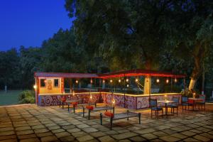 a restaurant with tables and chairs at night at Ramada Khajuraho in Khajurāho