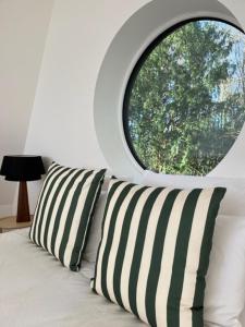 a bed with a window and a pillow on it at Nordic Bath Lodge In Normandy in Donnay