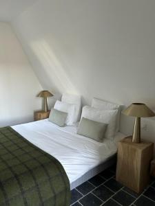 a bedroom with a bed with white sheets and pillows at Nordic Bath Lodge In Normandy in Donnay