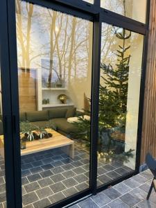 a view of a living room with a christmas tree through a window at Nordic Bath Lodge In Normandy in Donnay +8 photos