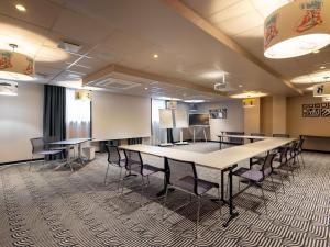 a conference room with a large table and chairs at Novotel Paris Suresnes Longchamp in Suresnes